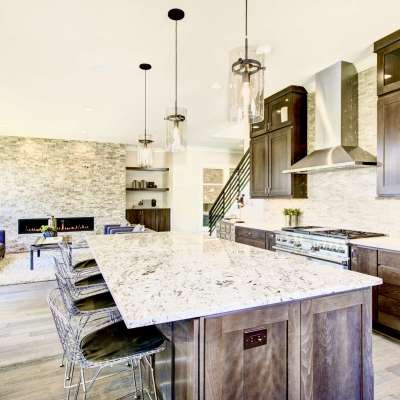 Luxury kitchen accented with large granite kitchen island, taupe tile backsplash, natural brown wood cabinets and high-end stainless steel appliances. Northwest, USA