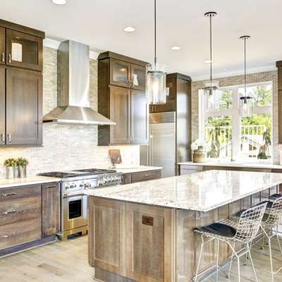 Luxury kitchen accented with large granite kitchen island, taupe tile backsplash, natural brown wood cabinets and lots of natural light. Northwest, USA